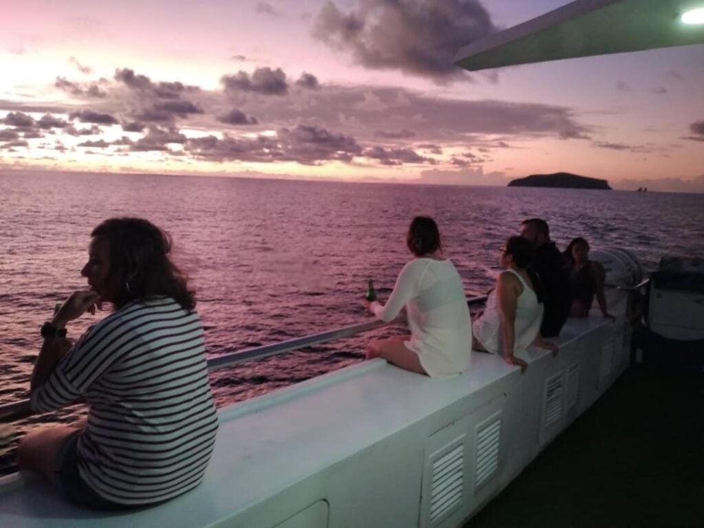 Divers enjoying a drink aboard Galapagos Master as the sun sets over the Pacific.