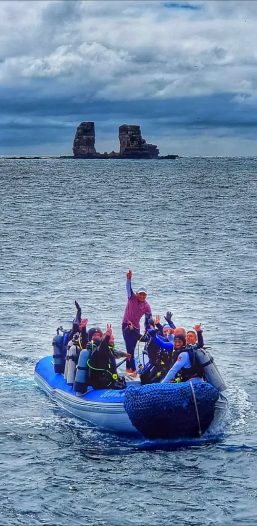 Dive team preparing to enter the water from a panga at Darwin’s Towers, one of the Galápagos’ most famous dive sites.