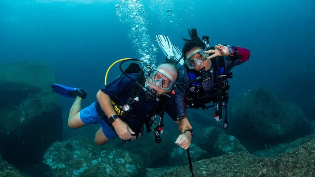 Divers drift across the boulders of the Similan Islands, improving their buoyancy all the way.