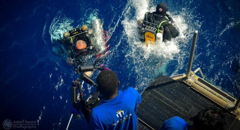 Technical divers entering the water from a liveaboard before a deep dive in Bikini Atoll