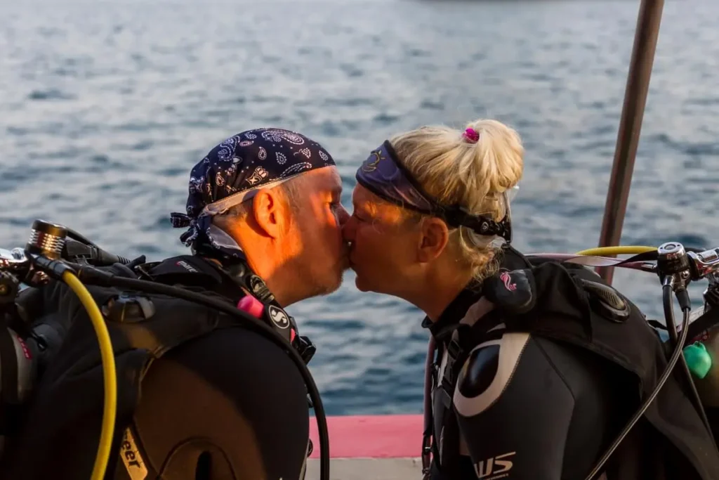 Couple of scuba divers sharing a kiss during a liveaboard diving trip.