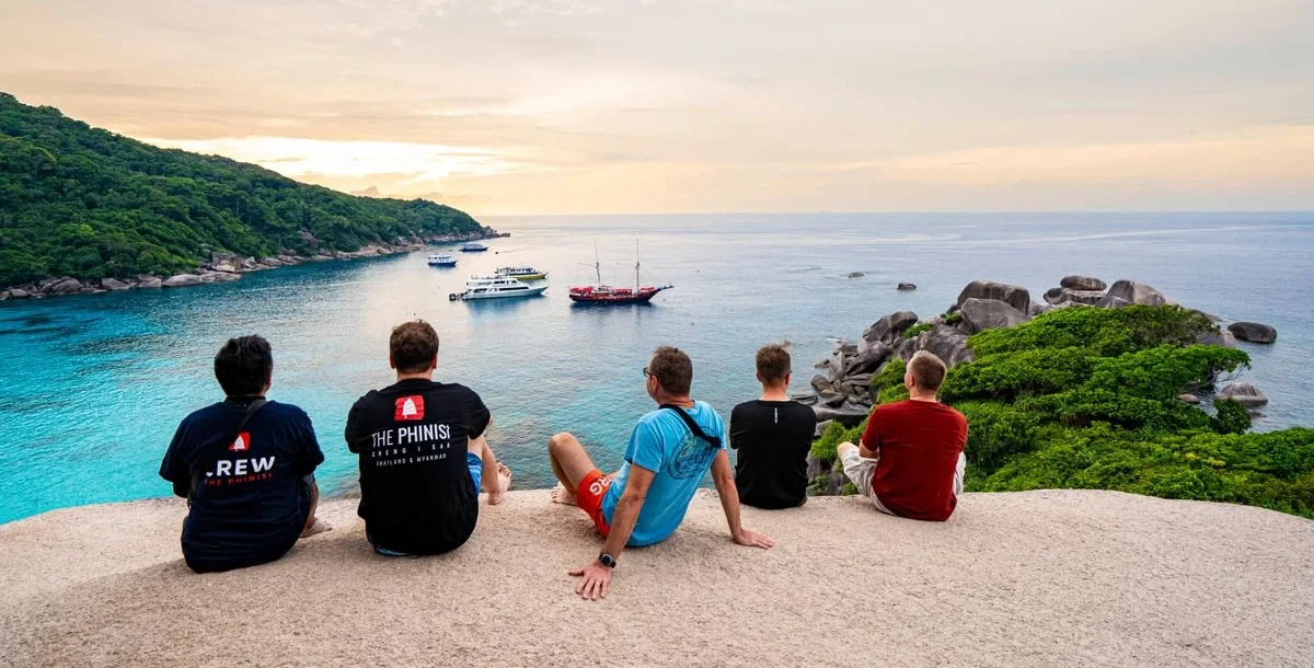 Group of friends and family enjoying a sunset during a shore excursion in Thailand on a liveaboard diving trip.