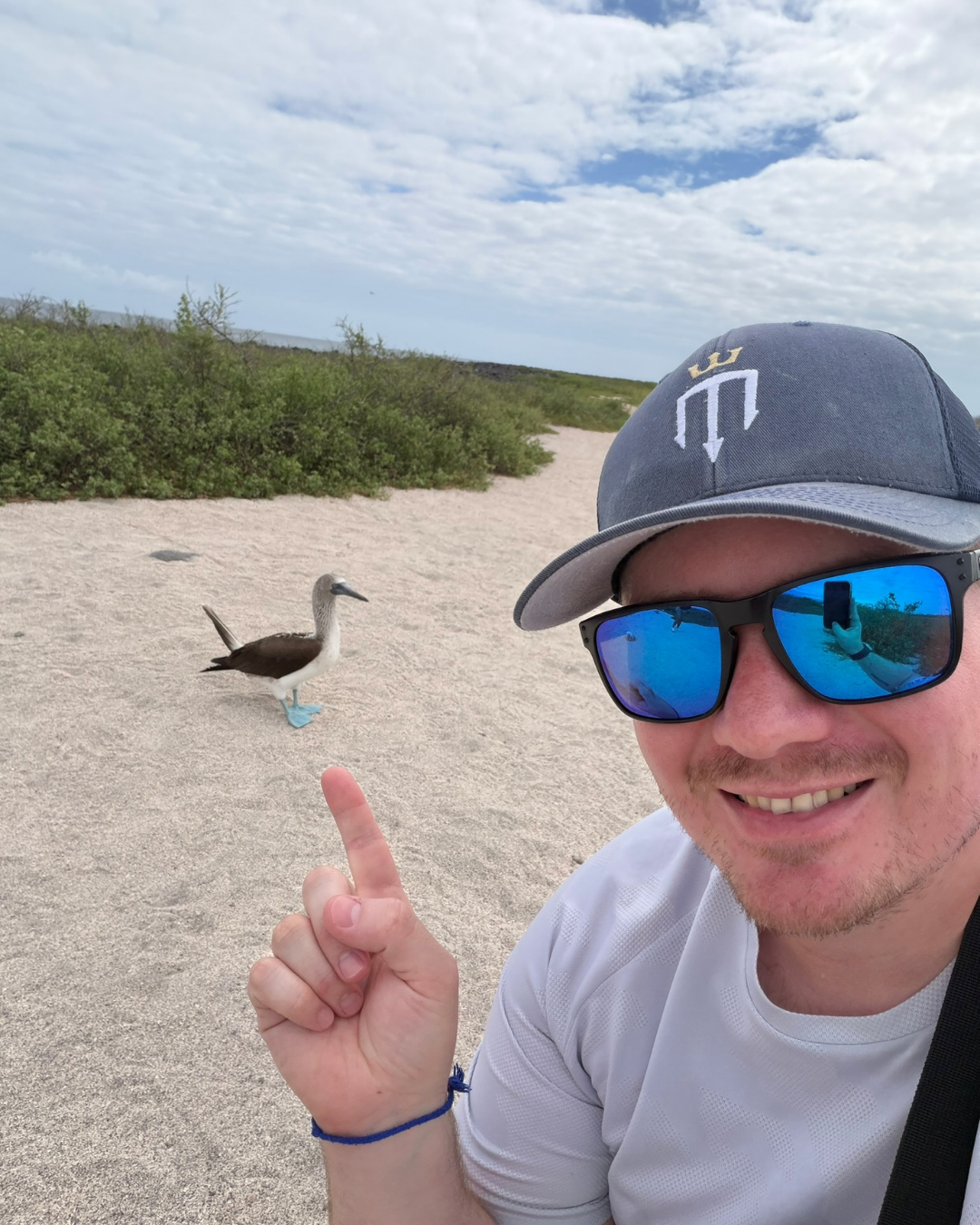 Blue-footed booby beside a Master Liveaboards guest on a Galapagos land tour